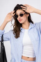 Camisa a rayas verticales color beige y blanco, con cuello clásico, cierre frontal con botones y mangas largas.