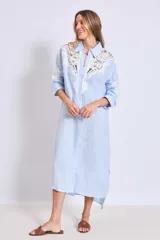 Vestido camisero celeste de lino con apliques de encaje blanco en cuello, mangas y frente.