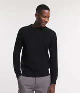 Suéter negro de algodón con cuello redondo y textura de punto.