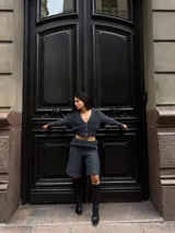 Campera de crochet de hilo celeste con negro, con cierre frontal y forro interior.