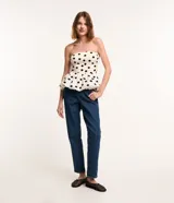 Pantalón mom confeccionado en jeans azul con trabillas en la cintura, cierre tradicional por botón y cremallera, bolsillos delanteros y traseros con detalle deshilachado.