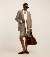 Blazer oversized con estampado de cuadros, cierre simple con dos botones, solapas de muesca y bolsillos delanteros con solapa.
