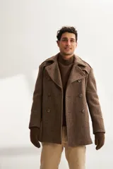 Saco marrón de lana con solapa, doble abotonadura, bolsillos, canesú y charreteras.