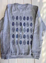 Buzo gris melange de corte clásico con cuello redondo, puños y cintura acanalados. Estampado frontal con el logo de la marca "Nativo" en azul marino.