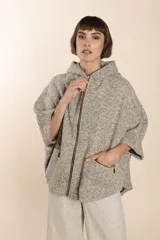 Capa color crudo de lana fina sin teñir, con capucha, cierre frontal y bolsillos con cierre.