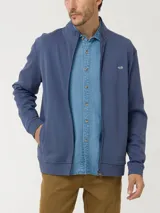 Buzo azul con cuello alto, cierre frontal y logo bordado en el pecho.