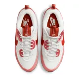 Zapatillas Nike Air Max 90 Futura de mujer, color blanco, rosa y rojo. Confeccionadas con materiales textiles y detalles de gamuza. Presentan la clásica cámara de aire visible en la entresuela y suela de goma con diseño waffle.