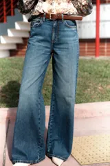 Pantalón de jean azul de tiro alto, corte wide leg, con cinco bolsillos, efecto lavado y cierre frontal con cremallera y botón.