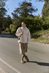 Camisa de denim color beige claro, corte amplio, cuello clásico, cierre frontal con botones y mangas largas. Confeccionada en tejido denim de sarga con acabado acid wash.