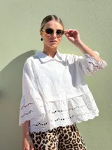 Camisa blanca de mangas 3/4 con detalles de broderie en las mangas y en el ruedo.