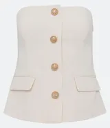 Blusa estilo corset color blanco, con escote recto, sin mangas, abotonado frontal y solapas aplicadas.