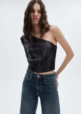 Blusa negra de fiesta con tejido metalizado, diseño asimétrico y una manga larga.