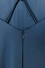 Vestido largo azul con cuello halter y tirantes finos. Detalle de aplique metálico en la espalda.