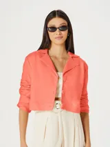 Blazer cropped color naranja con solapas y cierre frontal con botones.