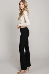 Pantalón negro de corte recto, tiro bajo y pierna angosta.
