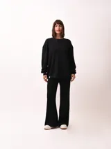 Pantalón palazzo negro de tejido de punto con cintura elastizada y cordón ajustable.
