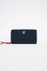 Billetera grande color azul marino con cierre perimetral y tirador rojo. Tiene el logo de la marca estampado en blanco en la esquina superior derecha.