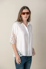 Camisa blanca lisa con aplique de guipiur en costados y mangas, de calce holgado.