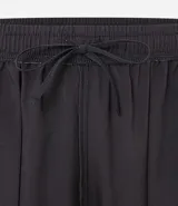Bermuda deportiva negra de poliéster con cintura elástica ajustable con cordón.