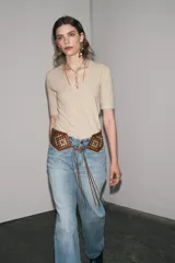 Camiseta color beige de lino con cuello en V y mangas cortas.