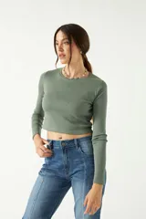 Remera blanca de manga larga con cuello redondo y corte cropped.