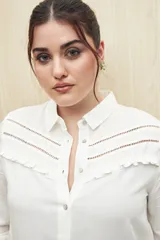 Camisa celeste de manga larga confeccionada en viscosa ligera, con detalles calados en la parte superior y pequeños volados.