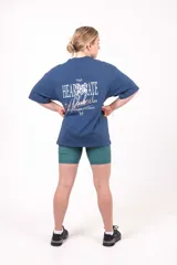 Remera oversize de algodón elastizado color azul, con diseño gráfico en la parte posterior.