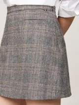 Minifalda gris con estampado de cuadros en tonos beige y negro, de corte evasé y largo a medio muslo.