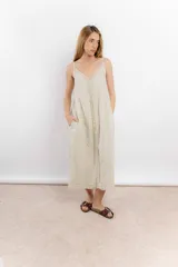 Vestido largo de lino color blanco, con breteles finos y detalle de costura o aplique vertical en el centro del frente.