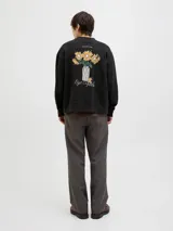 Buzo negro de manga larga con cuello redondo, fit oversize y estampa en la espalda con dibujo de flores en un jarrón.