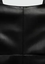 Mono corto negro efecto cuero, con tirantes anchos, cuello escotado y cierre lateral de cremallera.