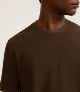 Remera de mangas cortas color crema, confeccionada con 50% algodón y 50% poliéster, con cuello redondo y tejido texturizado.