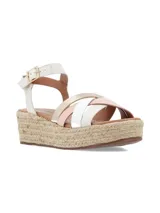 Sandalias de plataforma con suela de yute, tiras cruzadas de cuero negro y plateado, y pulsera al tobillo con hebilla metálica.