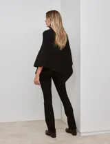 Poncho tejido color negro, con cuello polera y diseño de trenzas diagonales en el frente. Presenta un corte asimétrico en el ruedo.