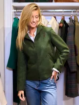 Campera corta de paño verde oscuro con cierre frontal, cuello alto y corte ligeramente acampanado.