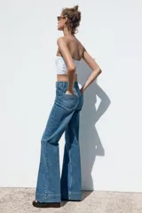 Pantalón de jean de tiro alto con bolsillos frontales y traseros. Corte recto y cierre frontal con cremallera y botón.