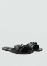 Sandalias planas color marrón cuero, con punta cuadrada, diseño de tiras y hebilla decorativa.