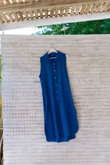 Camisola roja tipo vestido camisero, de corte midi, con cuello camisero, abotonada al frente y con abertura en el ruedo.