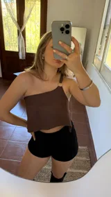 Top corto marrón de cuero sintético con un solo tirante y espalda ajustable.