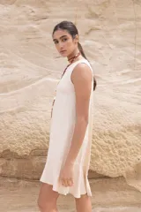 Vestido corto color beige, sin mangas y con cuello redondo.