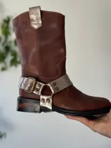 Bota de cuero marrón con estribo desmontable plateado.