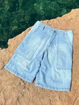 Short de jean celeste con bolsillos delanteros y traseros, y estampado con el logo de la marca en la pierna izquierda.