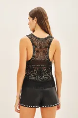 Top corto sin mangas, confeccionado en tul bordado con piedras, lentejuelas, canutillos y flecos de mostacillas.