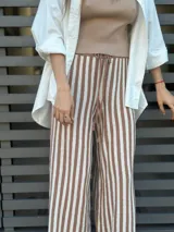 Pantalón de punto a rayas verticales color camel y crudo, con cintura alta y cordón ajustable.