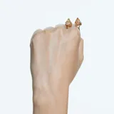 Anillo abierto unisex con baño en tono oro, con dos cristales tridimensionales de talla piramidal, uno transparente y otro amarillo.