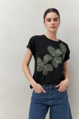 Remera blanca de manga corta con estampado floral en tonos dorados en el frente.