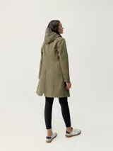 Trench color verde oliva con capucha y visera, cierre con botones a presión, bolsillos laterales con botones imantados, puño de manga regulable y cordones en la capucha. Tejido repelente al agua con aislamiento térmico y tecnología de eyelets en la sisa para mayor transpirabilidad y confort.