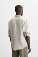 Camisa celeste de lino, de corte recto, manga larga y cuello clásico.