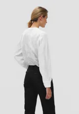 Blusa blanca de algodón con bordado de flores, cuello en V y mangas 3/4.