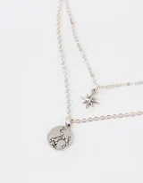 Collar multicadena plateado con dije de constelación y dije de estrella.